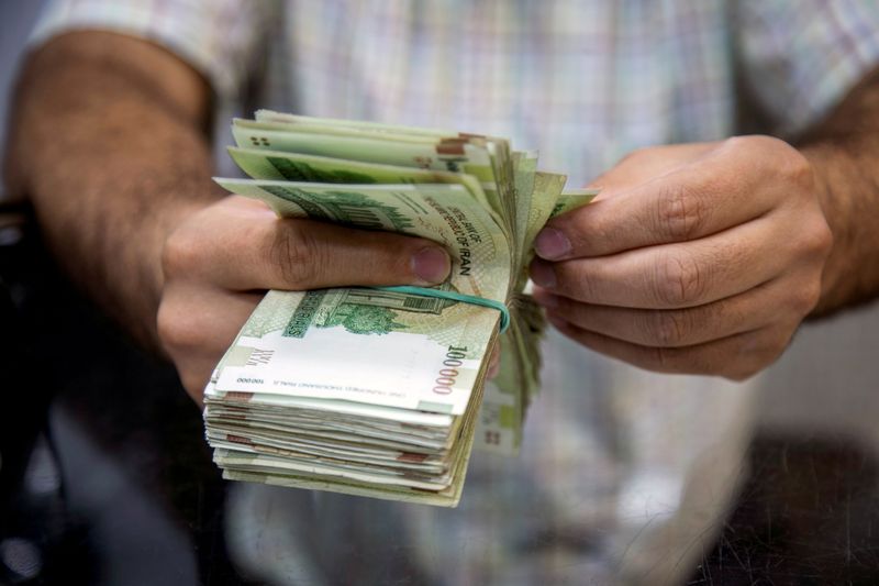 © Reuters. FILE PHOTO: A salesman counts money in Tajrish Bazaar, Tehran