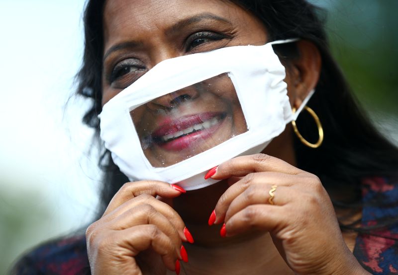 © Reuters. Director of Empowering Deaf Society Sutharsan, puts on a partially transparent mask in Ilford, London