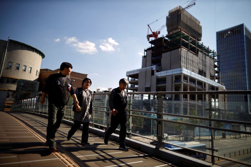 &copy; Reuters. FILE PHOTO: Workers walk past a construction site in Seoul