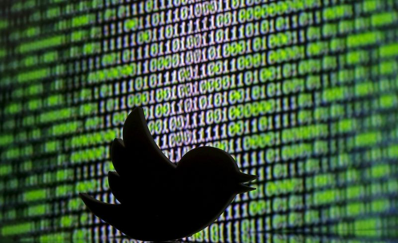 © Reuters. 3D printed Twitter logo is seen in front of a displayed cyber code