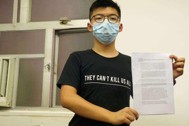 © Reuters. Hong Kong democracy activist Joshua Wong, wearing a face mask, shows journalists his declaration in English regarding his disqualification as a candidate in elections for the legislature, during a news conference in Hong Kong