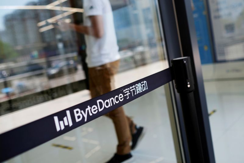 © Reuters. FILE PHOTO: Man walks by a logo of ByteDance, which owns short video app TikTok, at its offices in Beijing