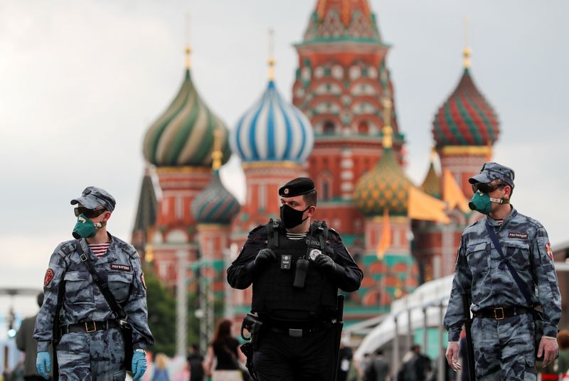© Reuters. Сотрудники правоохранительных органов в защитных масках на Красной площади в Москве
