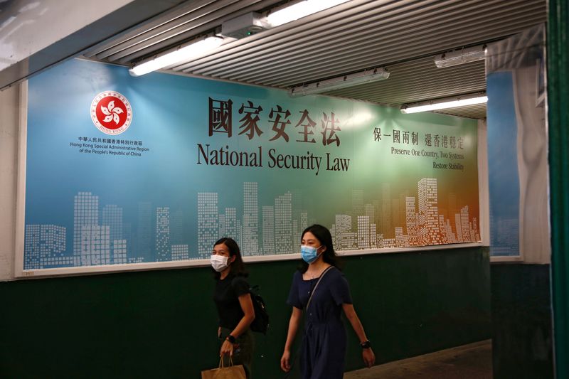 &copy; Reuters. FILE PHOTO: Women walk past a government-sponsored advertisement promoting the new national security law as a meeting on national security legislation takes place in in Hong Kong