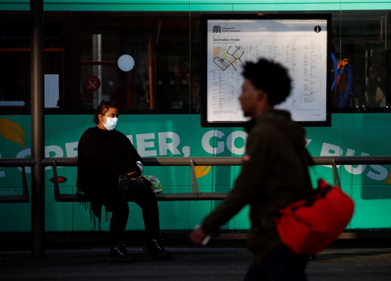 © Reuters. Una mujer porta una máscarilla protectora mientras espera el autobús en Mánchester, Reino Unido