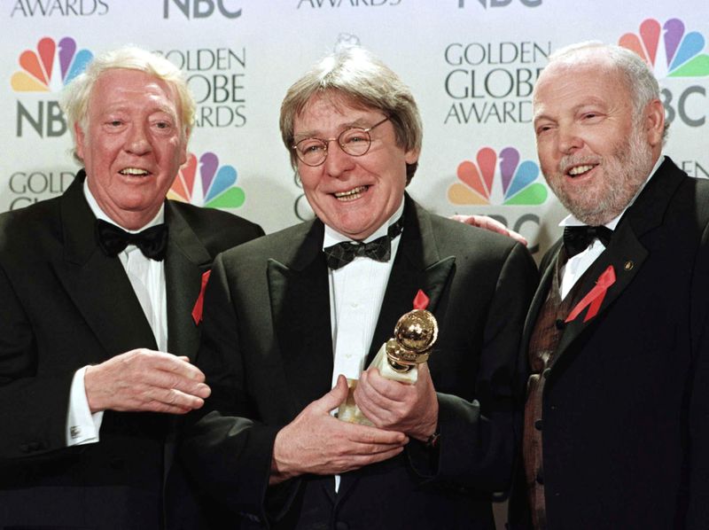 &copy; Reuters. FILE PHOTO: Producer Robert Stigwood (L), director Alan Parker and producer Andrew Vajna (R) celebrate the award