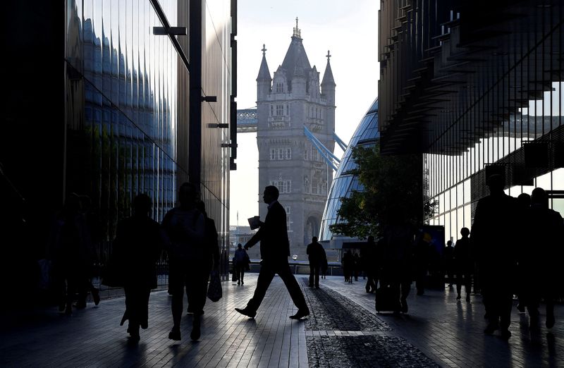 © Reuters. FILE PHOTO: Workers are seen in the More London district, with Tower Bridge behind during the morning rush hour in London