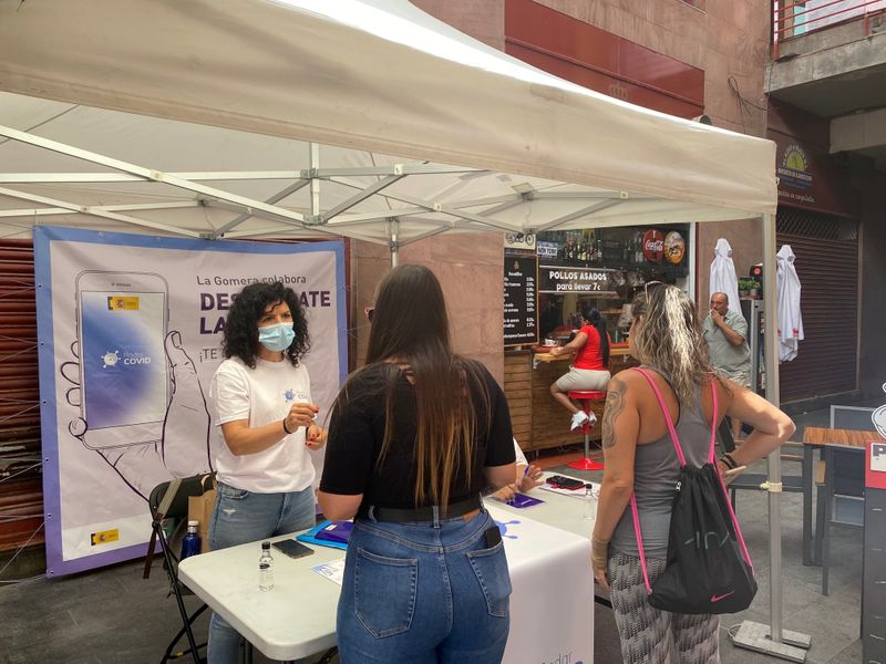 &copy; Reuters. FOTO DE ARCHIVO: Voluntarios muestran a los residentes cómo instalar una aplicación para rastrear contactos con personas potencialmente infectadas con la enfermedad de la COVID-19 en la isla canaria de La Gomera, España, el 3 de julio de 2020