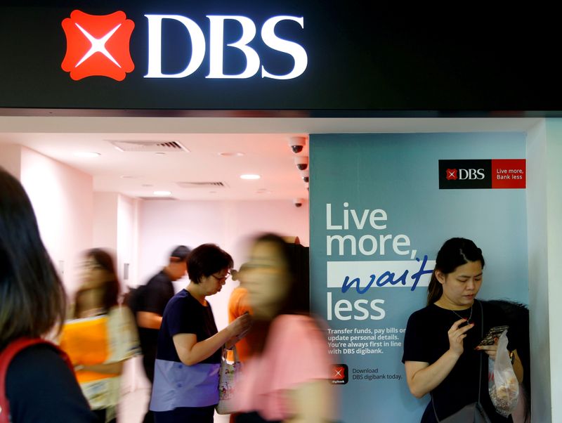 &copy; Reuters. FILE PHOTO: FILE PHOTO: People walk past a DBS branch in Singapore