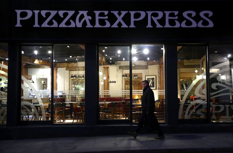 &copy; Reuters. A person is seen walking past an empty Pizza Express restaurant in London as the number of coronavirus cases grow around the world.