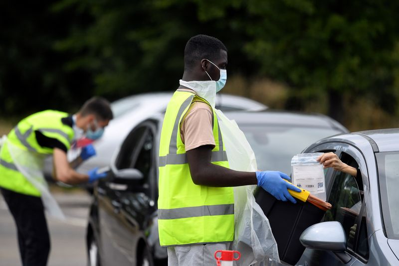 &copy; Reuters. Funcionários entregam e coletam kits de testes para detecção de Covid-19 em Londres