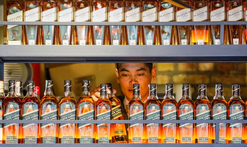 &copy; Reuters. FILE PHOTO: A bartender takes a bottle of Johnnie Walker whisky at Barmaglot bar in Almaty