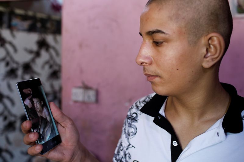 © Reuters. Iraqi teenager Hamid Saeed shows a video that circulated on social media of him being mistreated by members of security forces, after being released from jail during an interview with Reuters at his home in Baghdad