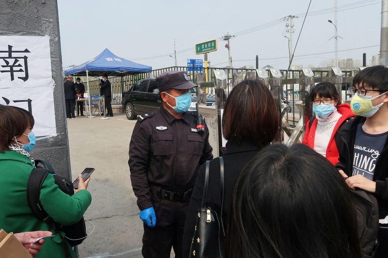 © Reuters. People wait at an entrance to a labour arbitration office in Beijing