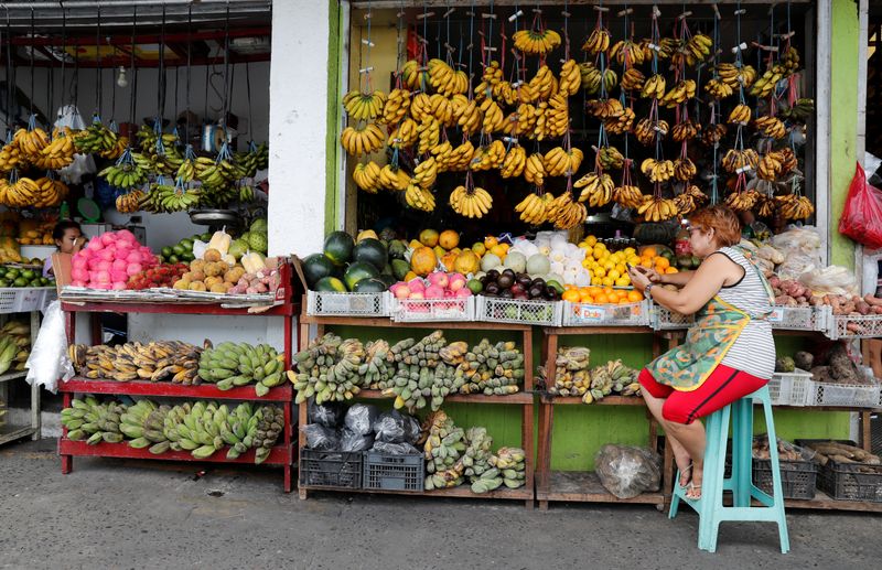 &copy; Reuters. A vendor surfs internet on her mobile phone as she waits for customers at a fruit stall at in Paranaque, Metro Manila