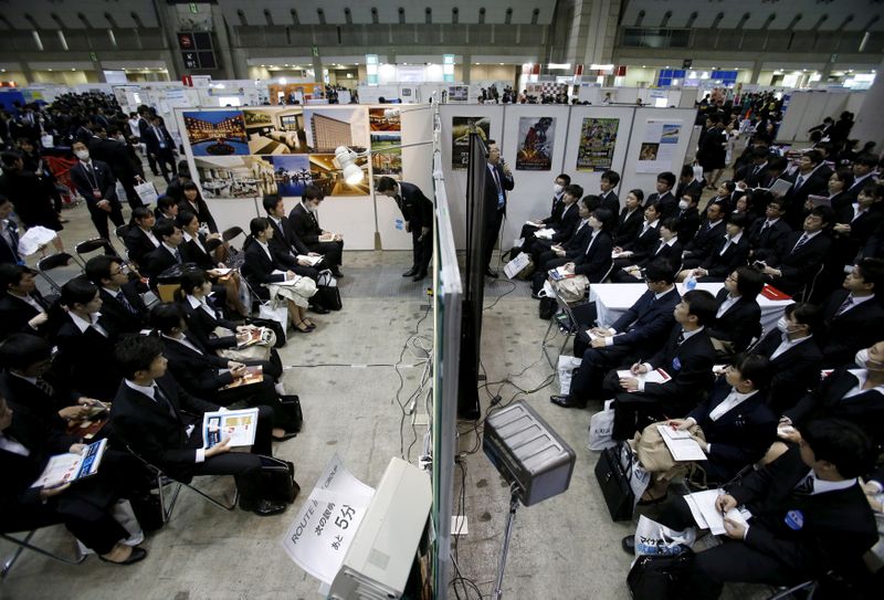 &copy; Reuters. FILE PHOTO: Job seekers attend orientation sessions at company booths during a job fair held for fresh graduates in Tokyo