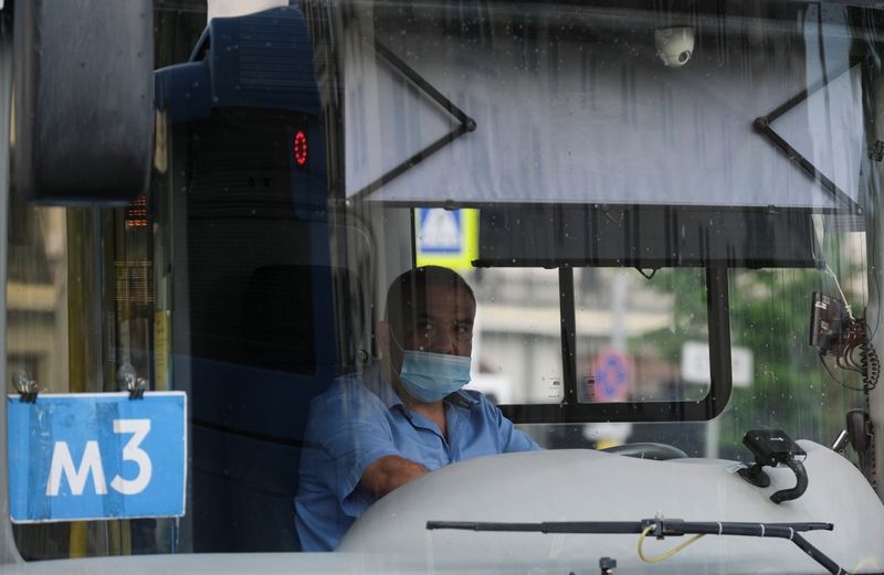 &copy; Reuters. Водитель автобуса в защитной маске