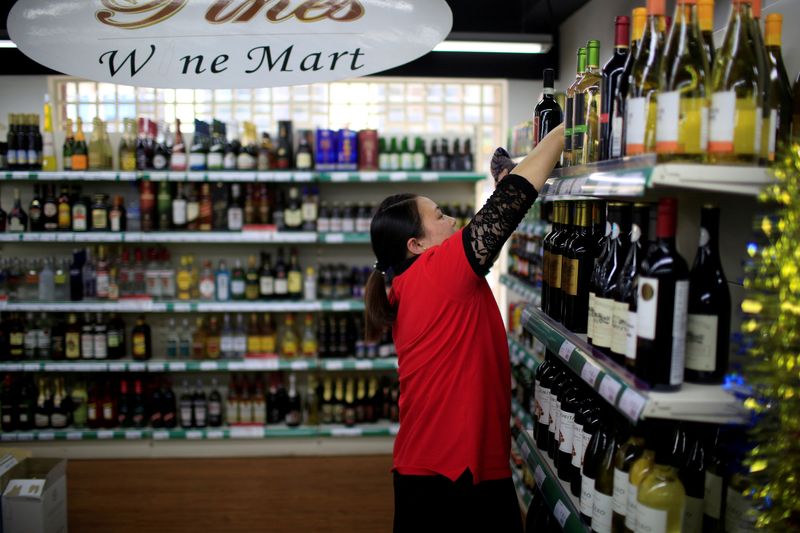 © Reuters. Funcionária checa garrafas de vinho em mercado de Xangai