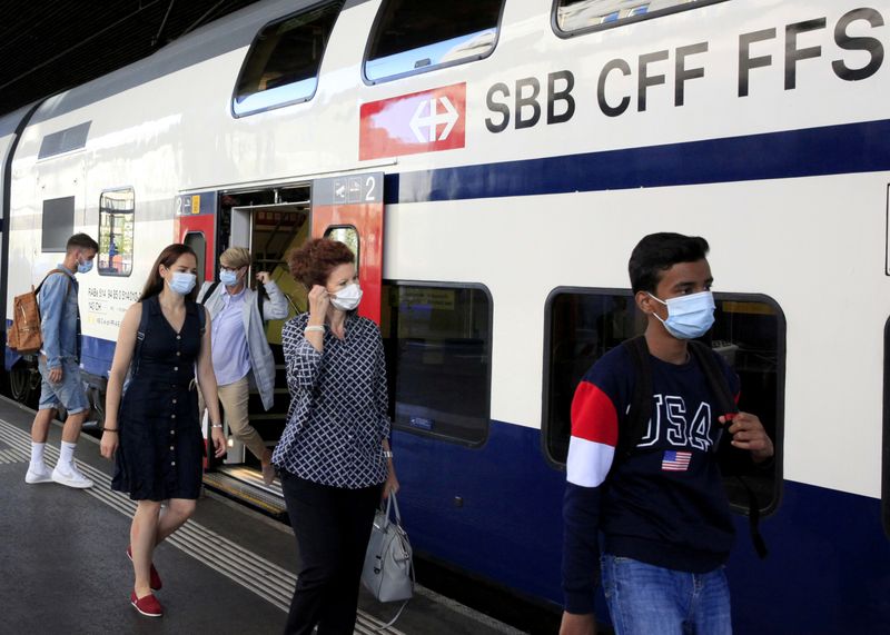 &copy; Reuters. FILE PHOTO: Passengers wear protective masks as they leave a train of Swiss railway operator SBB in Zurich, Switzerland