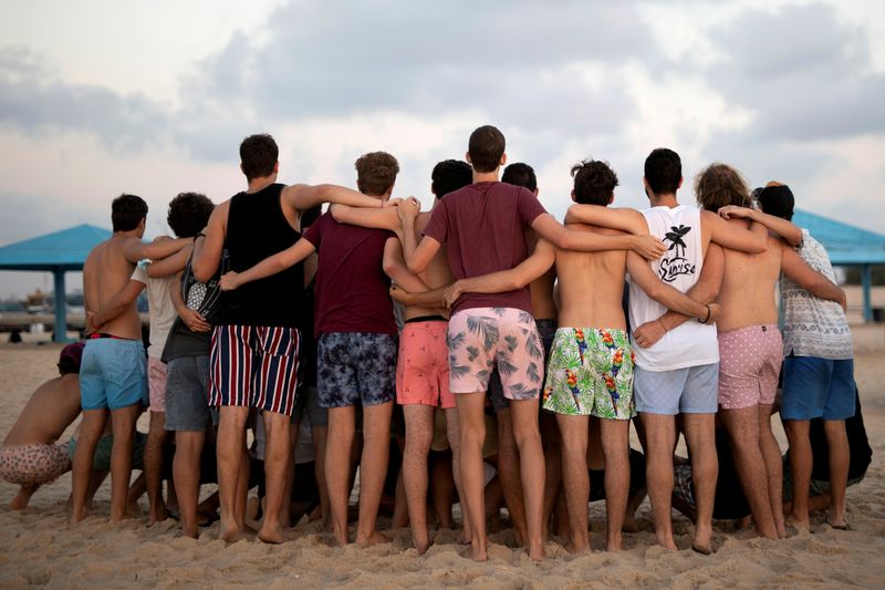 &copy; Reuters. FILE PHOTO: Youths wearing bathing suits, huddle together for a picture as they visit Zikim beach, amid the coronavirus disease (COVID-19) outbreak, in southern Israel