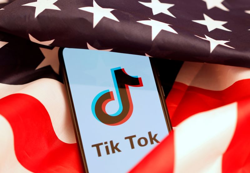 © Reuters. Tik Tok logo is displayed on the smartphone while standing on the U.S. flag in this illustration
