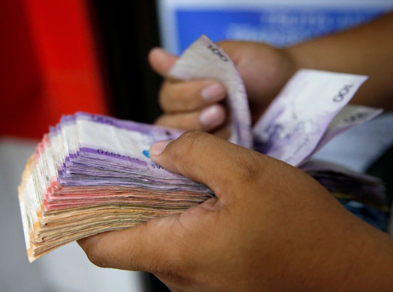 &copy; Reuters. Man counts wad of Philippine Peso bills in Makati