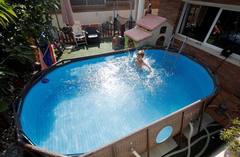 &copy; Reuters. Albert and Gonzalo Cano Lapuente cool off in a Bestway Above Ground Pool in Premia de Mar