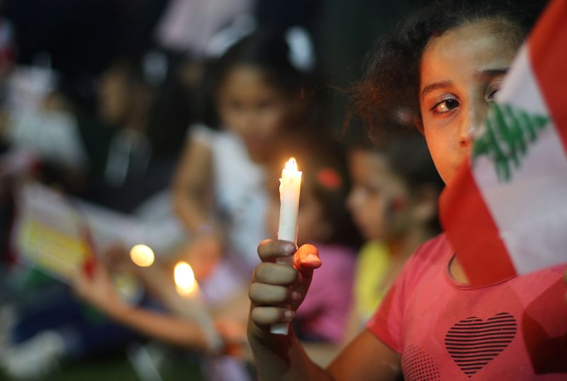 &copy; Reuters. Crianças palestinas acendem velas em solidariedade ao povo libanês após explosão na região portuária de Beirute