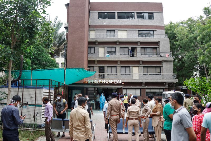 © Reuters. Policiais e familiares aguardam do lado de fora de hospital após incêndio na UTI matar pacientes com Covid-19 na Índia