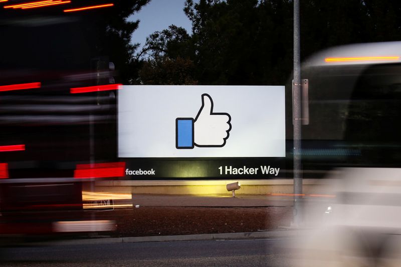 &copy; Reuters. FILE PHOTO:  The entrance sign to Facebook headquarters is seen through two moving buses in Menlo Park