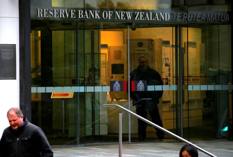 &copy; Reuters. Pedestrians walk past as a security guard stands in the main entrance to the Reserve Bank of New Zealand located in central Wellington, New Zealand