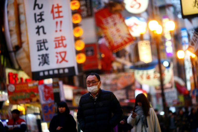 © Reuters. A man, wearing protective mask following an outbreak of the coronavirus disease (COVID-19), walks on an almost empty street in the Dotonbori entertainment district of Osaka