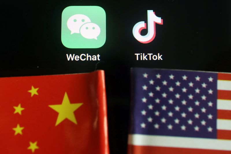 &copy; Reuters. Логотипы приложений Wechat и TikTok рядом с флагами Китая и США