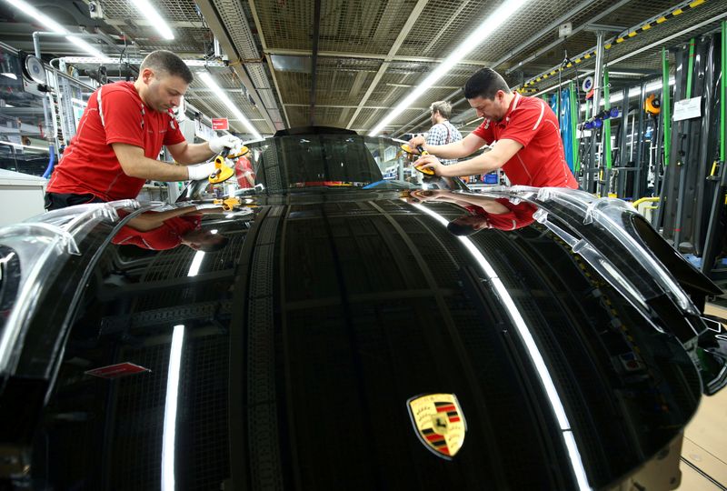 &copy; Reuters. FILE PHOTO: Employees of German car manufacturer Porsche install the windshield of a Porsche 911 at the Porsche factory in Stuttgart-Zuffenhausen