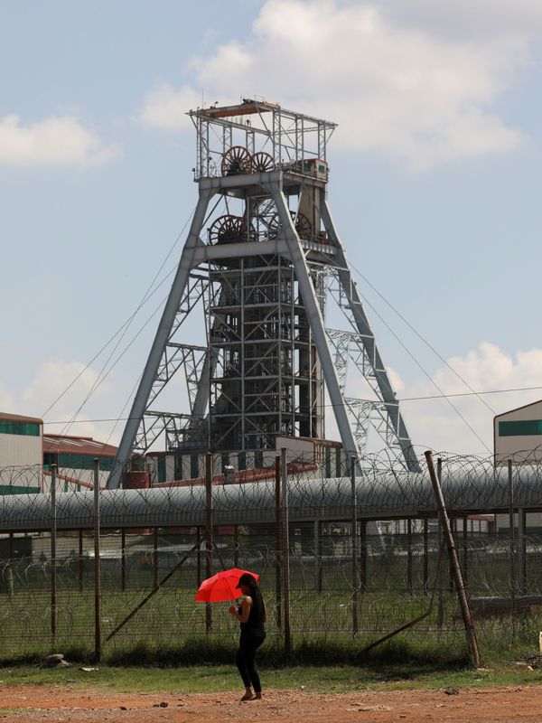 &copy; Reuters. FILE PHOTO: A woman walks past a shaft at Harmony Gold&apos;s Doornkop mine, 30km west of Johannesburg