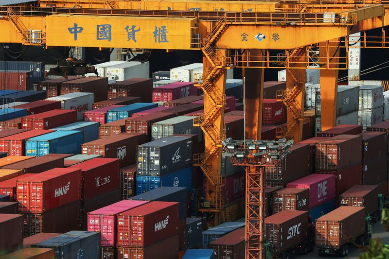 &copy; Reuters. FILE PHOTO: Trucks wait to be loaded on with containers at a port in Keelung