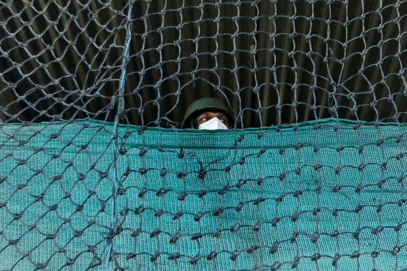 &copy; Reuters. FILE PHOTO: An Indian Central Reserve Police Force (CRPF) officer stands guard at a post during curfew ahead of the first anniversary of the revocation of Kashmir&apos;s autonomy, in Srinagar