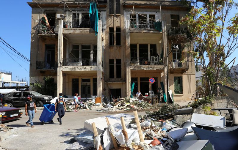 &copy; Reuters. Pessoas caminham perto de prédio danificado por explosão em Beirute