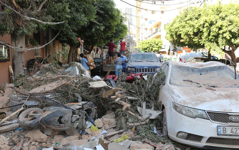 &copy; Reuters. Un grupo de personas junto a los escombros causados por la explosión del martes en el puerto de Beirut