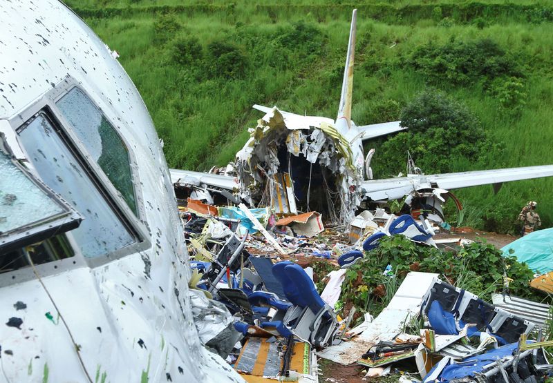 &copy; Reuters. A security official inspects the site where a passenger plane crashed when it overshot the runway at the Calicut International Airport in Karipur