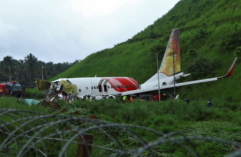 &copy; Reuters. Las autoridades inspeccionan el lugar donde se estrelló un avión de pasajeros al sobrepasar la pista del Aeropuerto Internacional de Calicut en Karipur