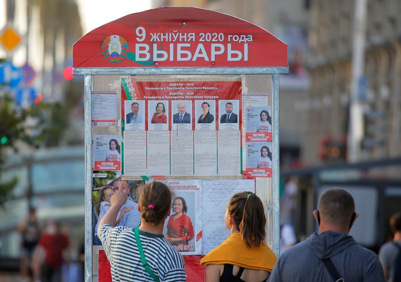 &copy; Reuters. People look at a presidential election information board in Minsk