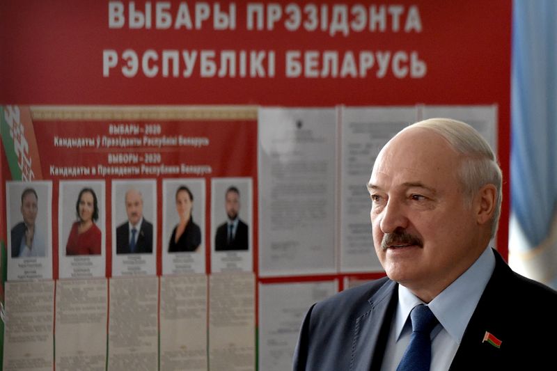 © Reuters. Belarusian President Alexander Lukashenko visits a polling station during the presidential election in Minsk