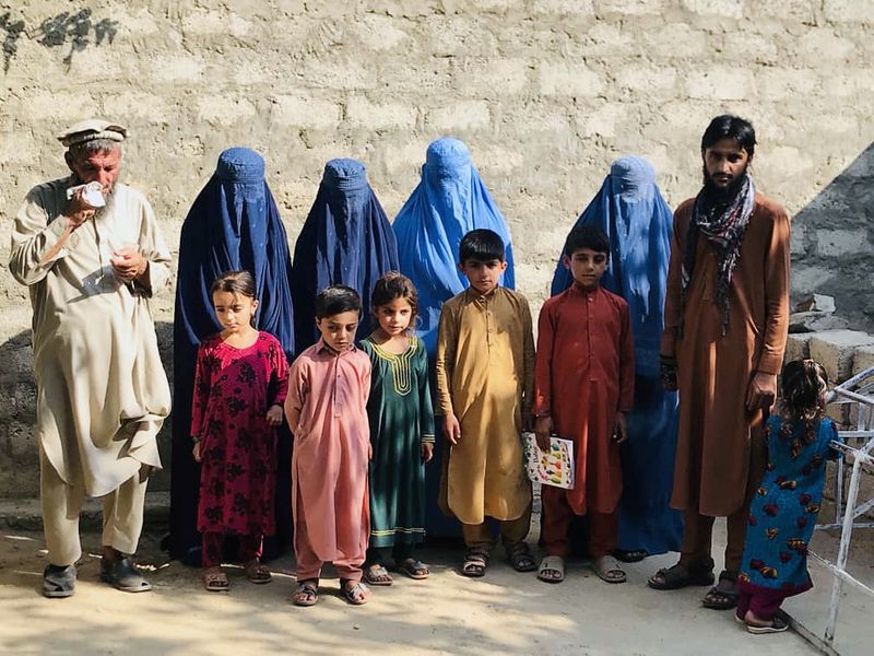 &copy; Reuters. Mohammed Jafar poses for a picture along with widows of his three brothers, their children and his father, in Kunar