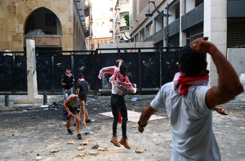&copy; Reuters. لبنانيون يرشقون الشرطة بالحجارة مع تفاقم الغضب من انفجار مرفأ بيروت