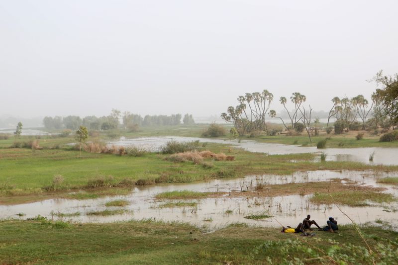 © Reuters. Men rest on the banks of the Niger River in Niamey