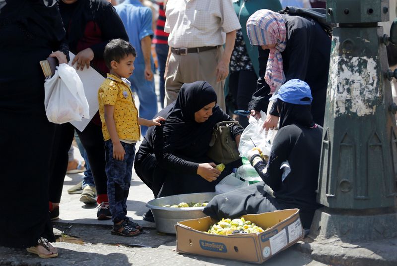 &copy; Reuters. FILE PHOTO: Egyptians buy fruits from street vendor at the central of Cairo