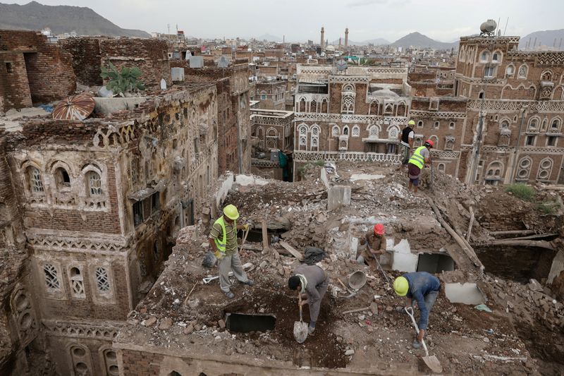 © Reuters. Workers demolish a building damaged by rain in the UNESCO World Heritage site of the old city of Sanaa