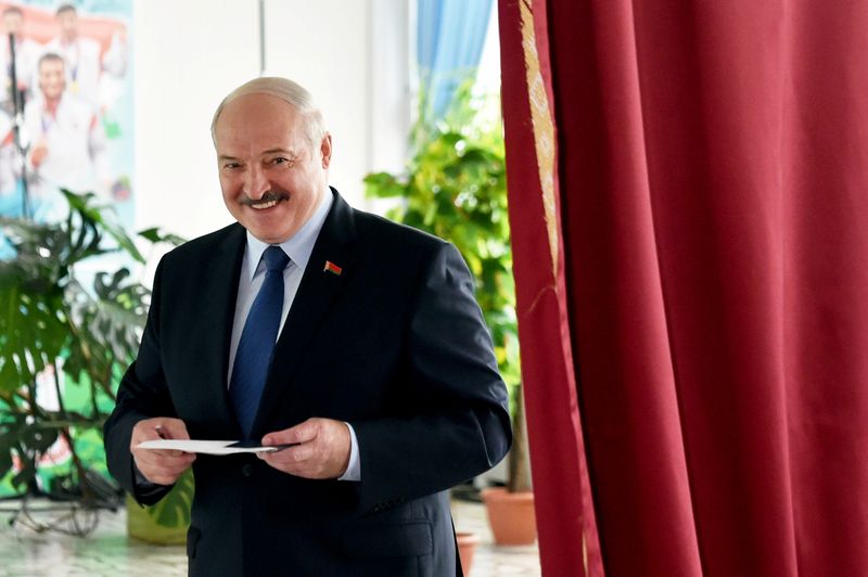 © Reuters. Belarusian President Alexander Lukashenko visits a polling station during the presidential election in Minsk
