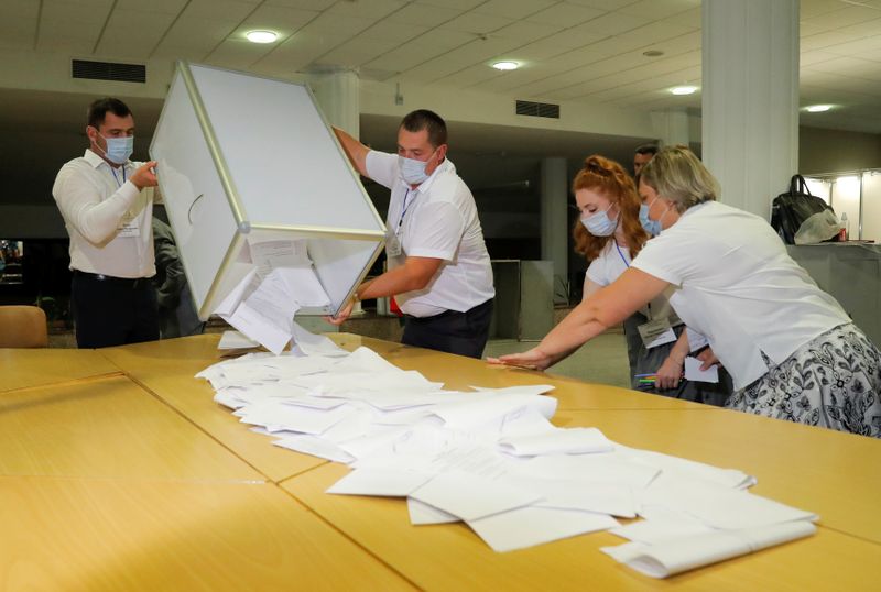 © Reuters. Сотрудники местной избирательной комиссии готовятся к подсчету бюллетеней на избирательном участке во время президентских выборов в Белоруссии